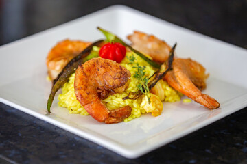 Shrimp risotto finely decorated with Pitanga fruit (Eugenia uniflora).