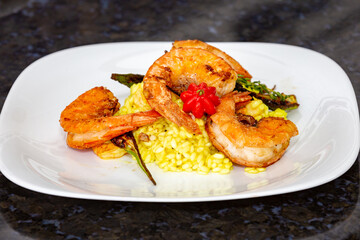 Shrimp risotto finely decorated with Pitanga fruit (Eugenia uniflora).