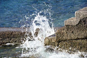 White wave that splashing stone stairs to the sea on the beach