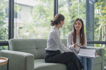 Confident young asian business woman working on laptop. Creative female executives meeting in modern startup office.