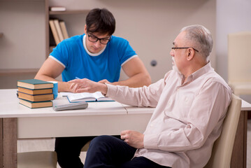 Obraz premium Young male student and his grandfather at home