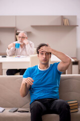 Obraz premium Young male student and his grandfather at home