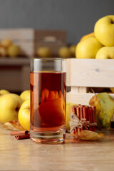 Fresh juicy apples in in wooden box and glass of apple juice.