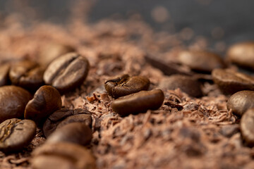 Roasted coffee beans lie together with chocolate crumbled into small pieces
