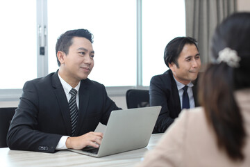 Collaborative process of professional businesspeople going over on new project together, using computer presentation and brainstorming ideas, coworker and working together at office meeting concept