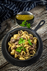 Italian pasta shells with beef sauce in cast iron pan.