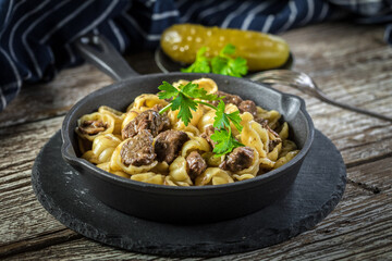 Italian pasta shells with beef sauce in cast iron pan.