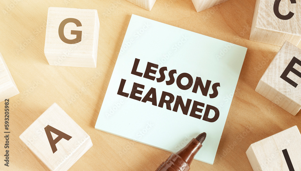Aufkleber Sticker with text Lessons Learned in the middle of wooden cubes with letters
