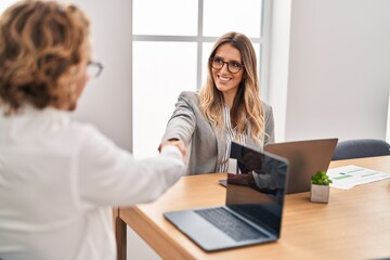 Man and woman business workers shake hands working at office