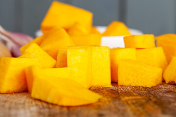 Sweet ripe orange pumpkin is sliced on the table