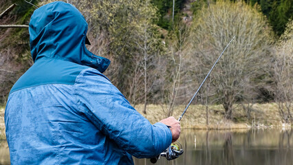A fisherman is fishing at a cloudy weather.