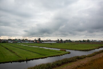 Fototapeta na wymiar Beautiful landscape of a field and a river under a cloudy sky.