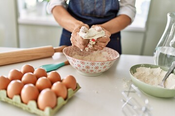 Young blonde woman make pizza dough with hands at kitchen