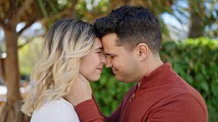 Fototapeta premium Man and woman couple smiling confident hugging each other at park