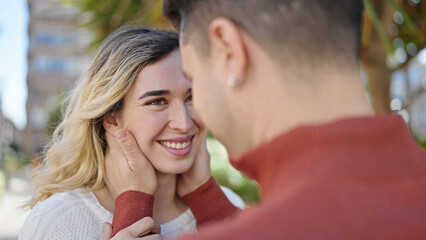 Fototapeta premium Man and woman couple smiling confident hugging each other at park