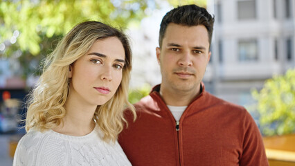 Man and woman couple standing together with relaxed expression at park