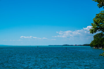 Fototapeta na wymiar Germany, Beautiful panorama view bodensee blue lake water coast from lindau, sailboats lake sunny day vacation mood