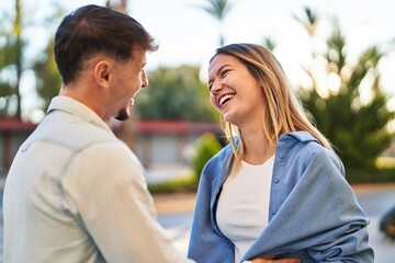 Fototapeta premium Young man and woman couple smiling confident standing together at street