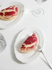 Fotobehang Vertical shot of a cut red crinkle cookie with crackles on plates © Jingluo/Wirestock Creators