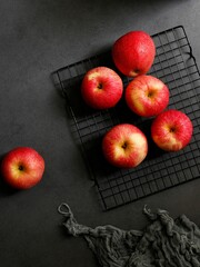 Vertical shot of red apples with a black fabric on a black table
