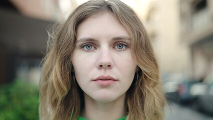 Fototapeta premium Young blonde woman standing with serious expression at street