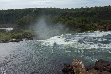 Landscape scene of Iguazu waterfalls with wood trees with blue sky in Argentina