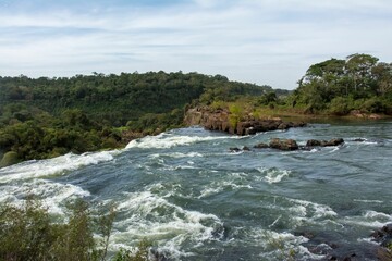 Landscape scene of Iguazu waterfalls with wood trees with blue sky in Argentina