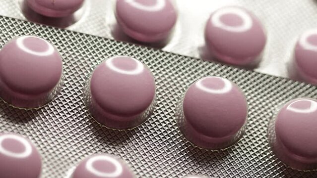 Pink tablets in blister rotate in circle