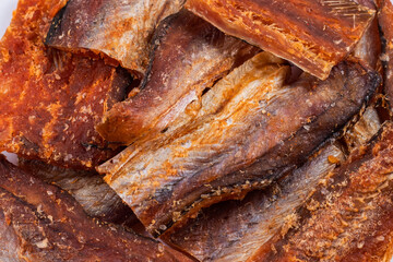 Pieces of cleaned dried fishbackground. Dry Peppered Pollack. Amber with pepper Collection