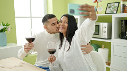 Man and woman couple make selfie by smartphone holding glass of wine at home