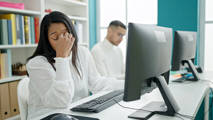 Man and woman students using computer stressed at university classroom
