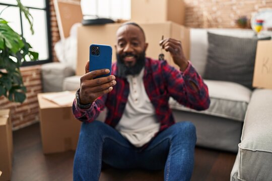 Young african american man make selfie by the smartphone holding key of new house at new home