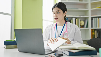 Young beautiful hispanic woman doctor using laptop at library university