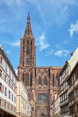 Fototapeta na wymiar Vertical low angle shot of the historic Strasbourg Cathedral exterior against a blue sky in France
