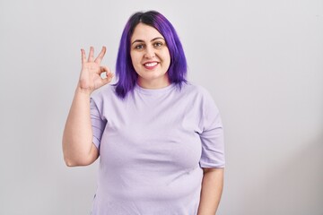 Plus size woman wit purple hair standing over isolated background smiling positive doing ok sign with hand and fingers. successful expression. - obrazy, fototapety, plakaty