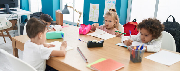 Group of kids students sitting on table studying at classroom