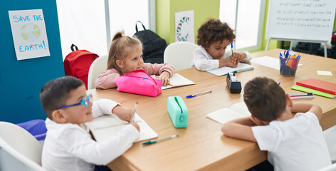 Group of kids students sitting on table studying at classroom