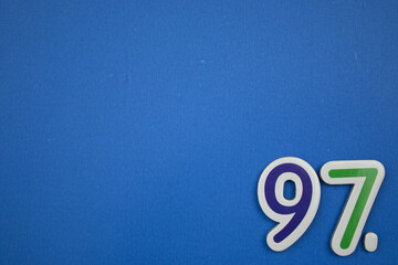 Placed on the edge of the blue background, colorful, the number 97.