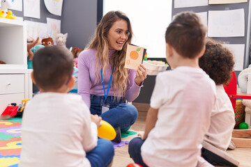 Woman and group of kids having vocabulary lesson with word cards at kindergarten