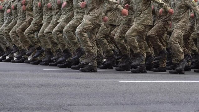 Military men marching in the parade. Soldiers legs. Boots forces and infantry soldier. Army march. Defender team. Crowd man go. Armed forces walking in a row. Pixel uniform. War background.