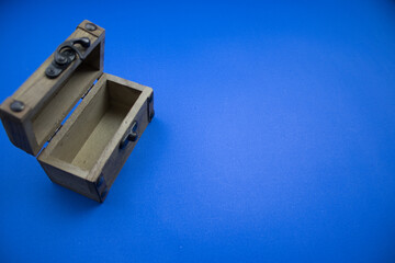 Fototapeta premium Wooden, open chest, placed on a blue background, photographed from above.