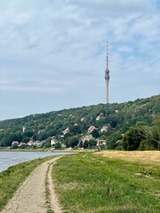 Obraz premium Vertical shot of a pathway at a lake on the background of the Fernsehturm Dresden