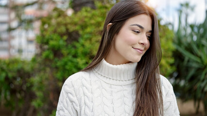 Naklejka premium Young beautiful hispanic woman smiling confident looking to the side at park