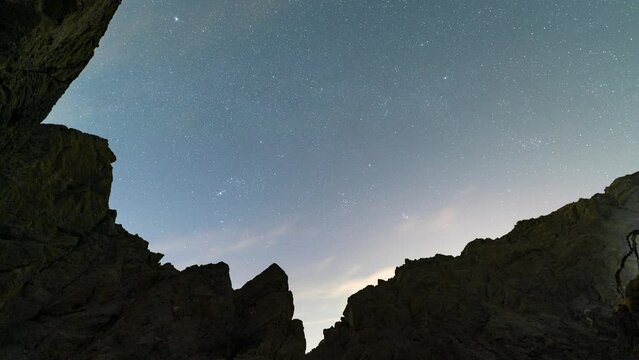 Time lapse of constellation Orion over desert mountain at night in Painted Canyon in California, USA