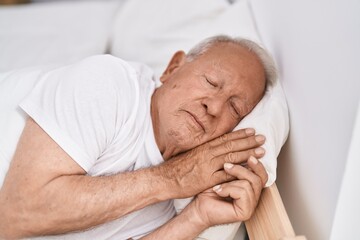 Fototapeta na wymiar Senior grey-haired man lying on bed sleeping at bedroom