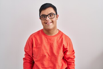 Young hispanic man with down syndrome standing over white background with a happy and cool smile on...