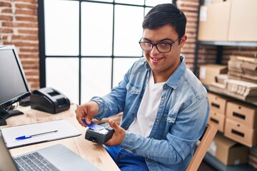 Down syndrome man ecommerce business worker using data phone and credit card at office