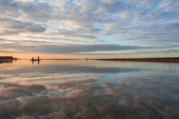 Amazing view at scenic landscape on a beautiful river and colorful sunset with reflection on water surface and glow on a background, spring season landscape, sunset over the river. river landscape.