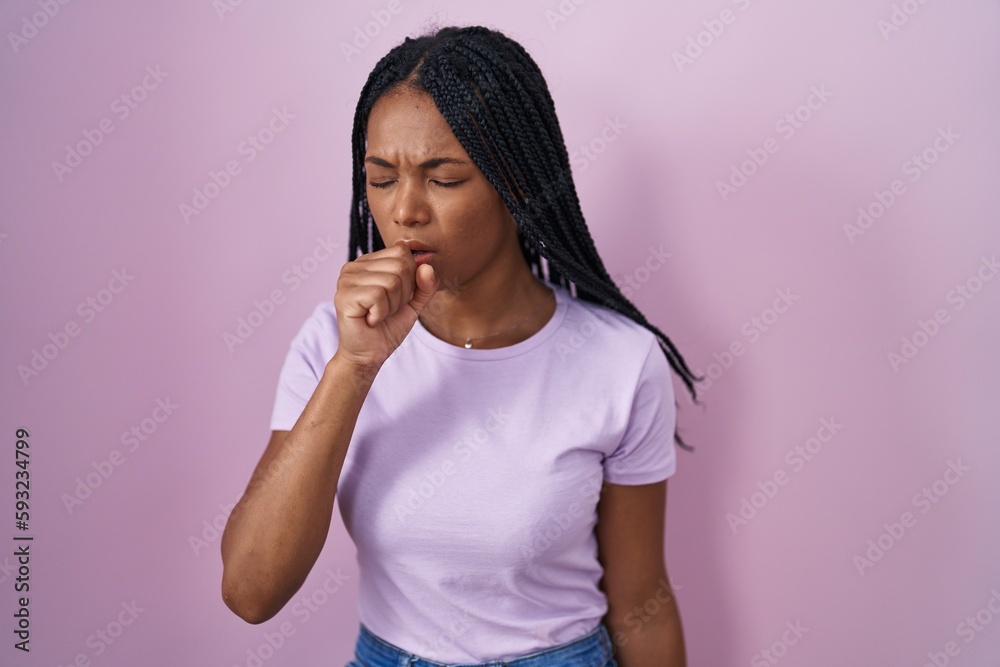 Wall mural African american woman with braids standing over pink background feeling unwell and coughing as symptom for cold or bronchitis. health care concept.