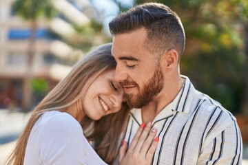 Obraz premium Man and woman couple smiling confident hugging each other at park